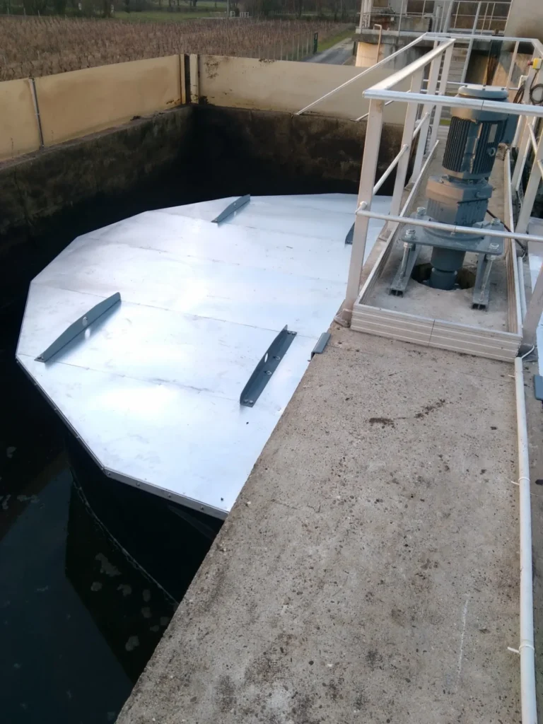 Installation d'une turbine lente de surface sur un bassin de traitement des eaux usées.