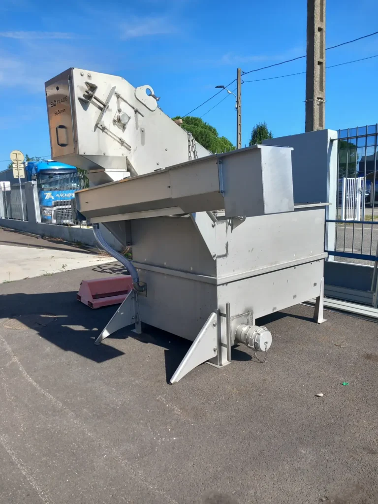 Vue arrière du dégrilleur matières de vidange BioScreen Biotrade positionné en extérieur avec caisson de réception et vis compacteuse