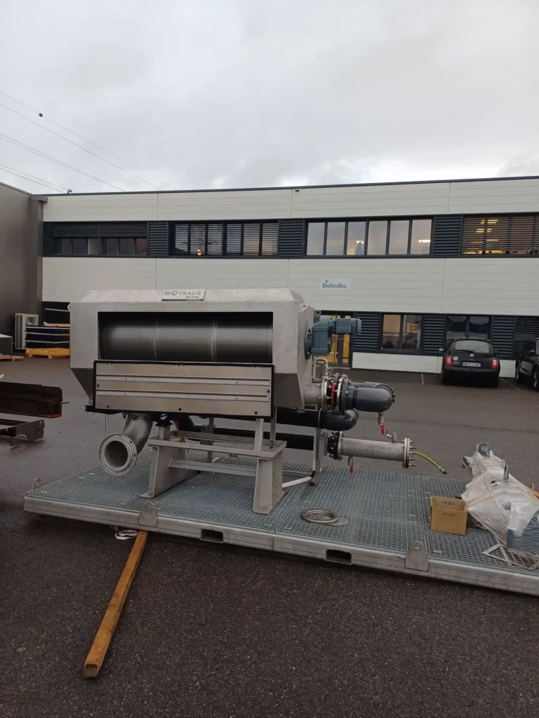 Tambour épaississeur BioThick Biotrade posé sur skid grillagé dans la cour de l'usine, prêt pour livraison