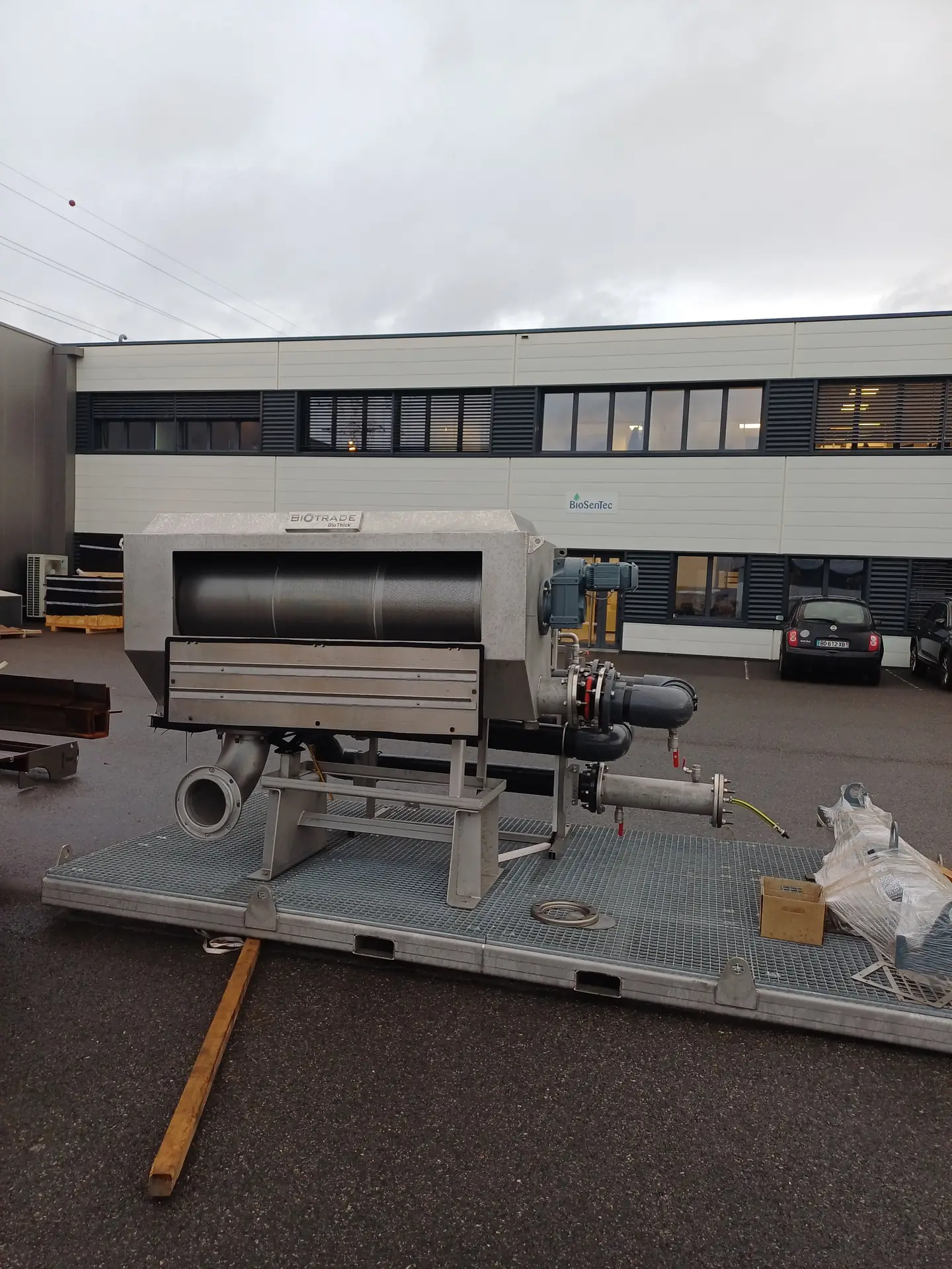 Tambour épaississeur BioThick Biotrade posé sur skid grillagé dans la cour de l'usine, prêt pour livraison