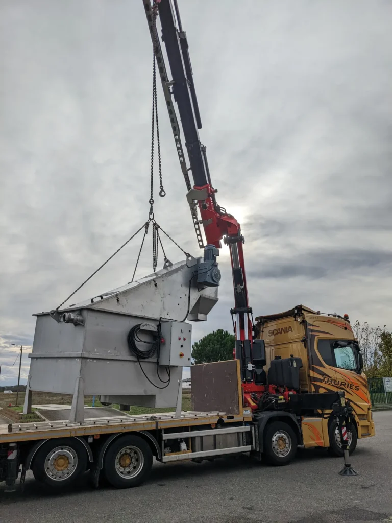 Dégrilleur matières de vidange Biotrade soulevé par grue Fassi sur camion Scania Thuries lors de la livraison sur site
