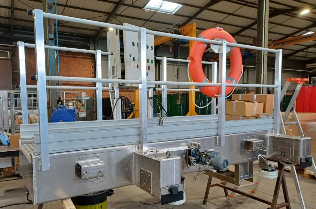 Pont baladeur dégraisseur Biotrade en aluminium avec passerelle, garde-corps et motoréducteur, photographié en atelier de fabrication
