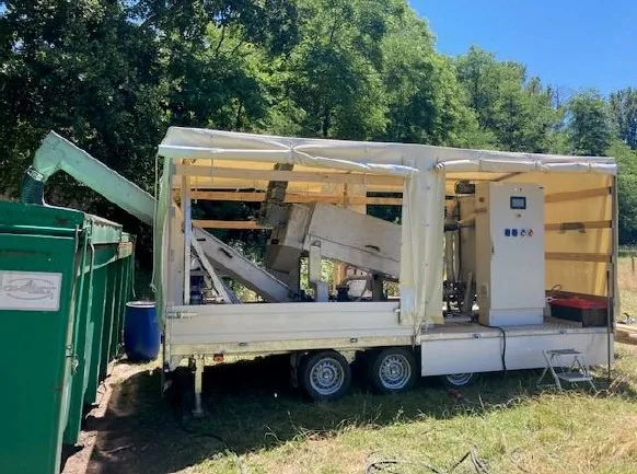 Remorque pilote Biotrade ouverte en extérieur avec presse à vis, armoire électrique et système de traitement des boues lors d'un essai sur site